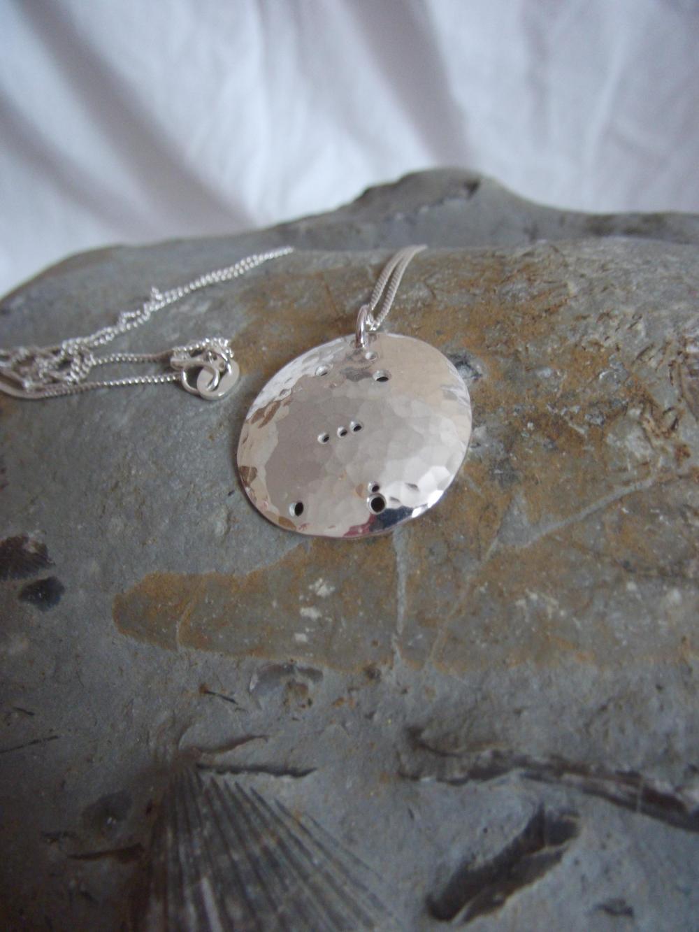 Silver Orion pendant: The constellation of Orion the hunter on a domed sterling silver disc.