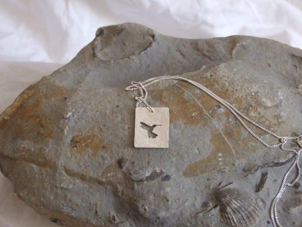 Silver Hummingbird pendant: A beautiful silhouette of a hummingbird on a background of textured sterling silver.