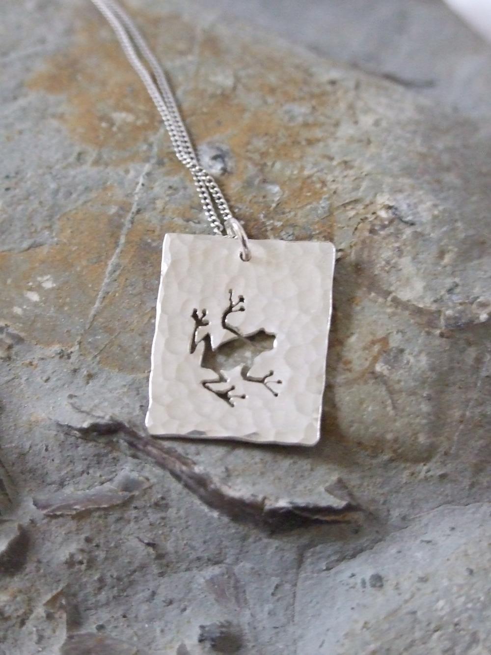 Silver Frog Pendant: A textured sterling silver pendant showing a silhouette of a hoppity frog.