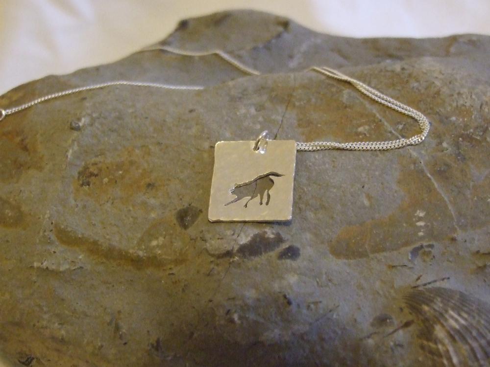Silver Fox Pendant: A playful fox silhouette pendant on a background of textured sterling silver.
