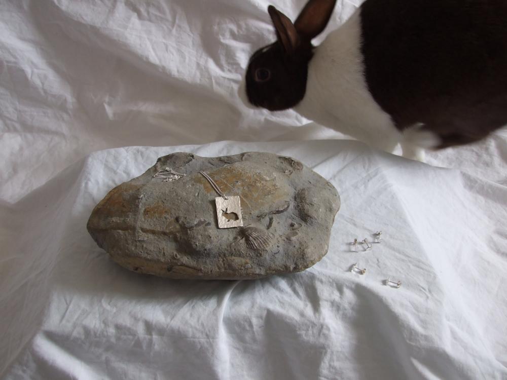 Silver rabbit pendant: The silhouette of a cute little bunny sitting against a background of textured sterling siver.
