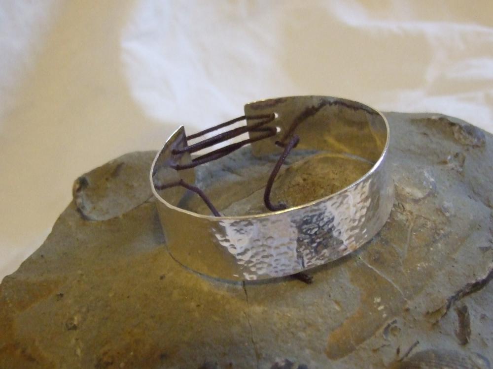 Silver textured bracelet with corset effect lace on the back