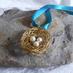 Brass Nest Pendant: A cute birds nest pendant made from wire with three white pearl bead eggs.
